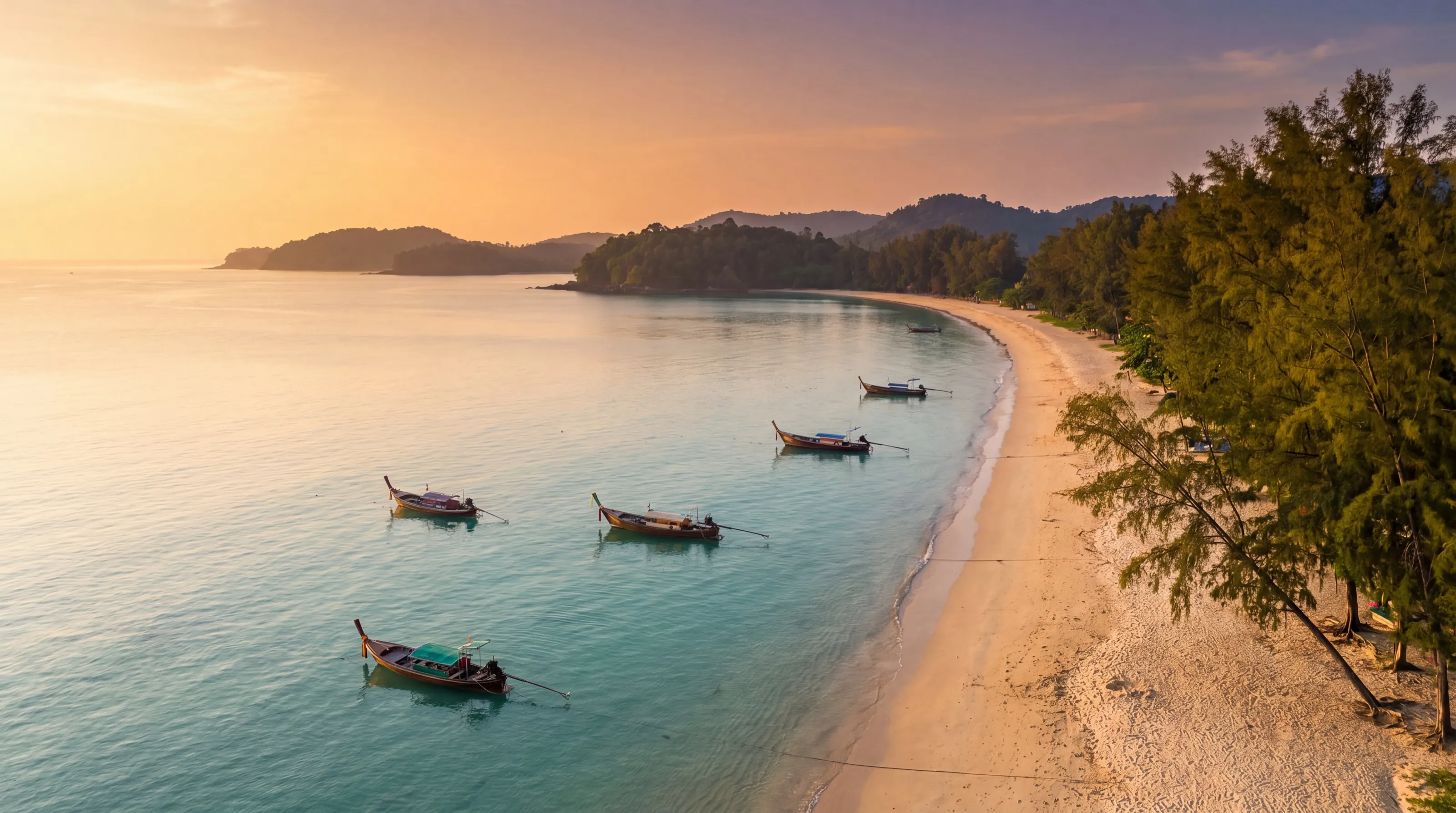 Nai Yang beach — casuarina pines over the water and longtail boats in Sirinat National Park